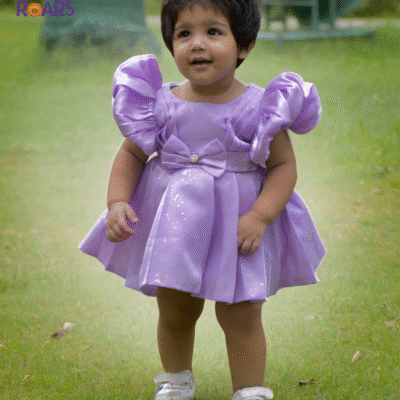 A dreamy lilac puff sleeve dress with sparkle and bows, made for your baby girl’s special moments.